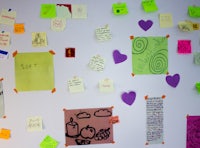 a white wall with a lot of post it notes on it